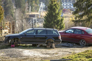 Abandoned cars on private land, one with wheels removed