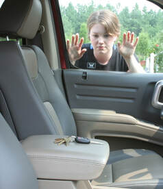 Young woman looks through window into car at keys that have been accidentally locked in the car